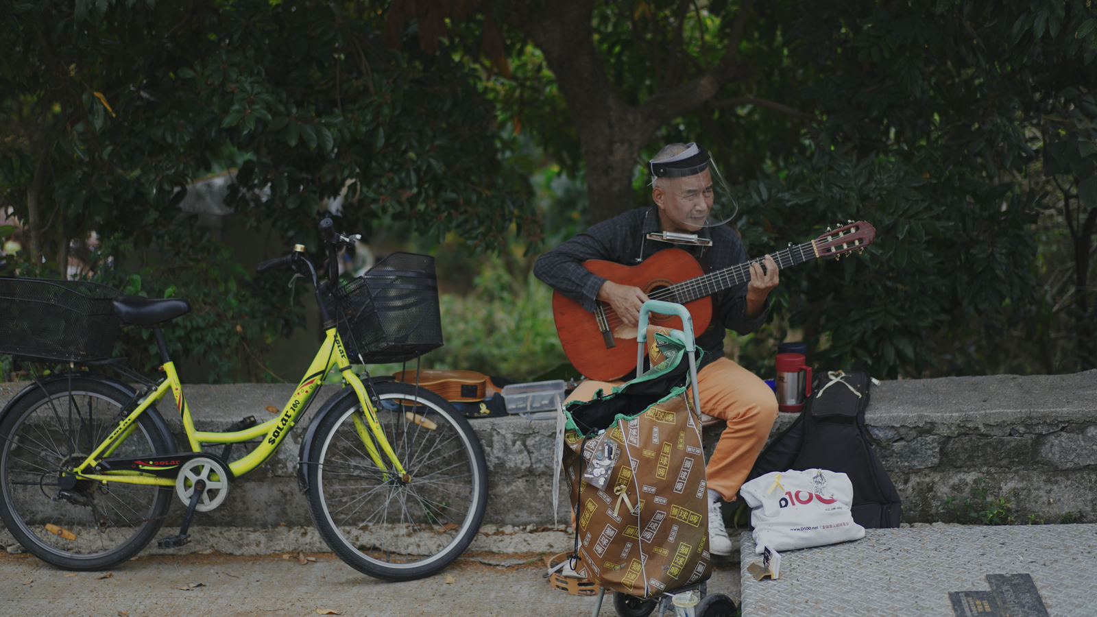 Street musician and his yellow bike